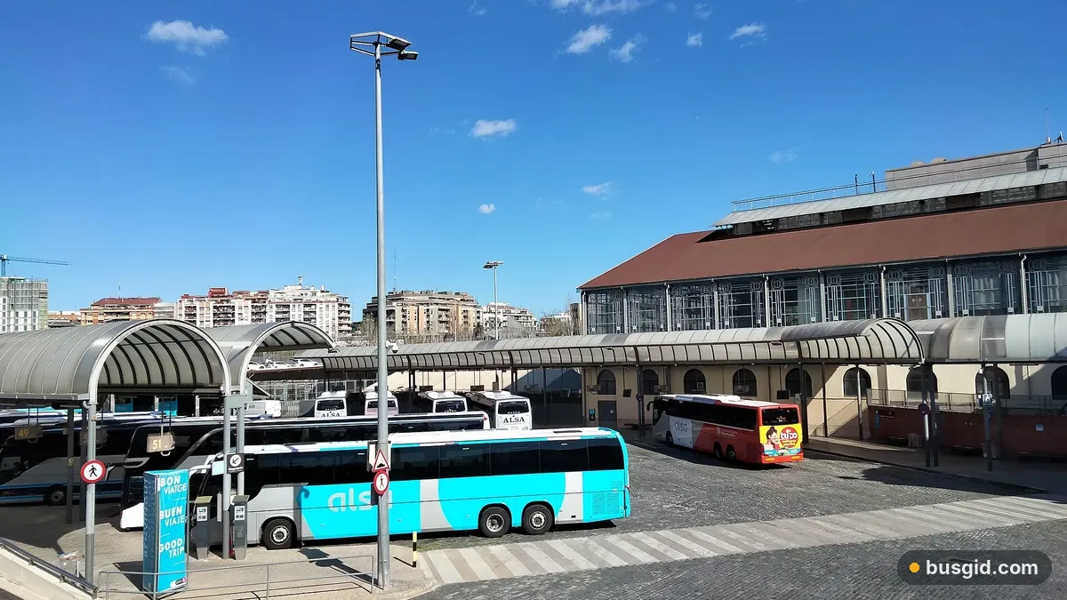 Перони автовокзалу Barcelona Nord з навісами, бірюзовий автобус ALSA біля історичної будівлі Estació del Nord