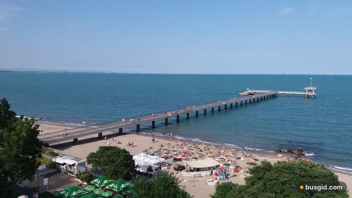 Довгий пірс Бургаса над Чорним морем і центральний пляж з парасольками, вид згори з Морського саду